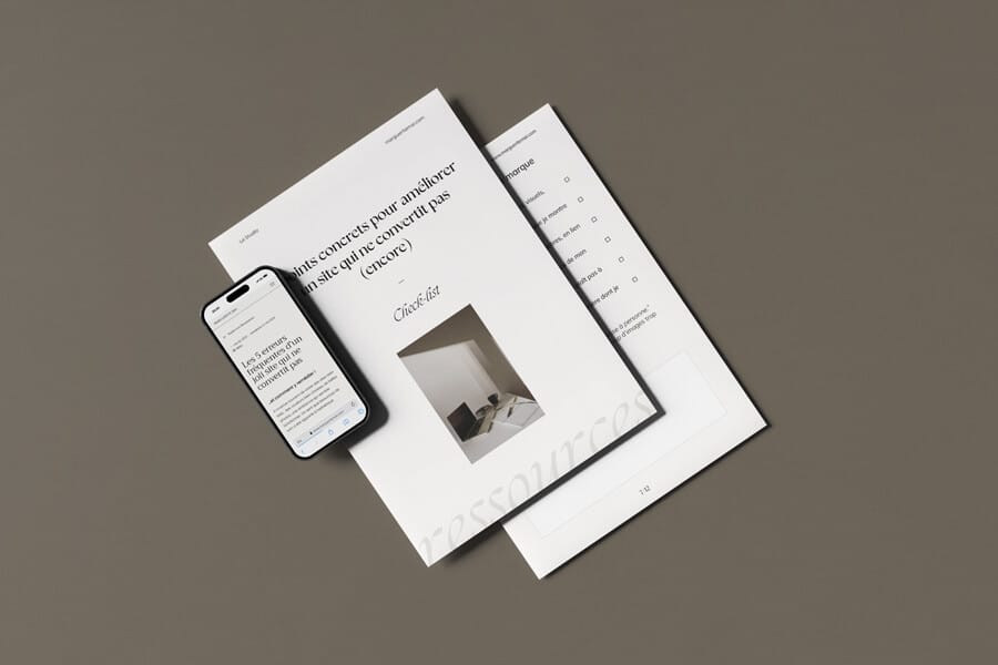 5 points concrets pour améliorer un site qui ne convertit pas Check-list sur papier des 5 points concrets à améliorer sur un site qui ne convertit pas, posé sur une table, à côté d'un iPhone