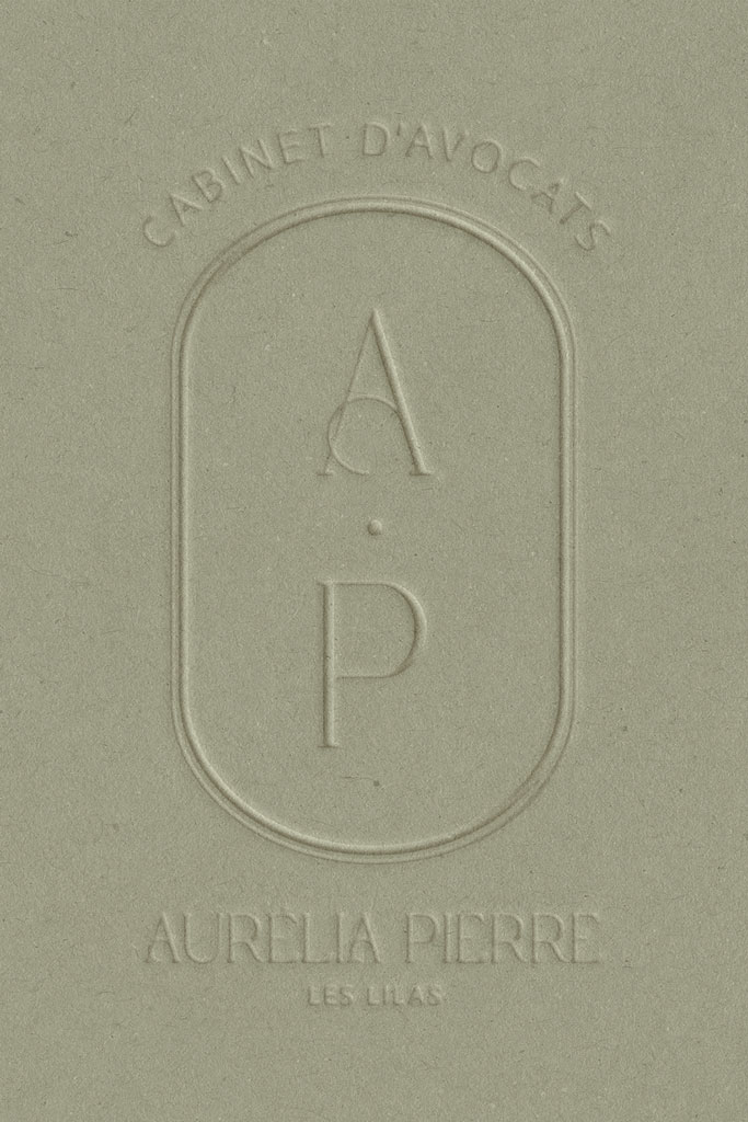 Présentation du logo du Cabinet d'Avocats Aurélia Pierre, embossé sur papier mat texturé vert.